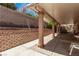 Relaxing covered patio features a brick retaining wall and concrete columns for stylish outdoor living at 2037 Merano Ct, Las Vegas, NV 89123