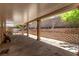 A serene covered patio with a brick retaining wall, concrete pillars, and outdoor seating space at 2037 Merano Ct, Las Vegas, NV 89123