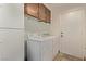 Practical laundry room with washer, dryer, cabinet storage, shelving and access to outside at 2037 Merano Ct, Las Vegas, NV 89123