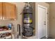 Image shows water heater in garage near shelving and cabinet storage at 2037 Merano Ct, Las Vegas, NV 89123