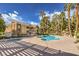Community pool with spa surrounded by palm trees and other mature landscaping at 2120 Ramrod Ave # 2216, Henderson, NV 89014