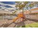 Community playground with slide and stairs surrounded by mulch and palm trees near a parking area at 2120 Ramrod Ave # 2216, Henderson, NV 89014