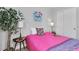 This cozy bedroom is decorated with a pink quilt, a potted plant, and charming artwork at 2271 Smokey Sky Dr, Henderson, NV 89052