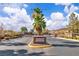 The Sunridge Manor community entrance featuring a monument sign, mature trees, and gated access at 2271 Smokey Sky Dr, Henderson, NV 89052
