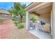 Cozy covered patio with an outdoor dining set, grill, and low-maintenance landscaping at 2522 Darda St, Henderson, NV 89044