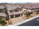 Aerial view of a two-story home featuring a tile roof, three-car garage, and landscaped front yard at 2575 Hazelburn Ave, Henderson, NV 89044