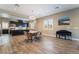 Open floor plan with dining table next to the kitchen with dark cabinets and stainless appliances at 2575 Hazelburn Ave, Henderson, NV 89044