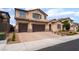 Charming two-story stucco home features a three-car garage and paved driveway at 2575 Hazelburn Ave, Henderson, NV 89044