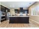 Modern kitchen featuring a large island, stainless steel appliances, and a view to a window at 2575 Hazelburn Ave, Henderson, NV 89044