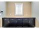 Ample storage space featuring cabinets and drawers beneath a window and dark countertops at 2575 Hazelburn Ave, Henderson, NV 89044