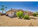 Tan home with stone accents and desert landscaping including drought-resistant rock and green shrubbery at 2851 Winchester Ave, Pahrump, NV 89048
