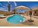Inviting backyard pool with a tanning ledge, patio furniture, and an umbrella at 2851 Winchester Ave, Pahrump, NV 89048