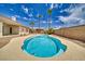 Backyard in-ground pool with a unique shape surrounded by palm trees and desert landscaping at 2851 Winchester Ave, Pahrump, NV 89048