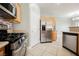 Open kitchen with stainless steel appliances and light wood cabinets seamlessly leading into the dining area at 3312 Speckle Summer Pl # 3, North Las Vegas, NV 89084