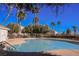 Community pool featuring palm trees and clear blue water, perfect for relaxation at 3312 Speckle Summer Pl # 3, North Las Vegas, NV 89084