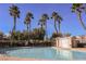 Large community pool surrounded by tall palm trees provides a tropical oasis for residents at 3312 Speckle Summer Pl # 3, North Las Vegas, NV 89084