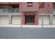 Entrance to condo building with gray-beige concrete exterior, covered doorway, and garage entrances at 35 E Agate Ave # 208, Las Vegas, NV 89123