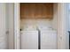 A laundry room featuring a white washer and dryer, as well as wooden cabinets for storage at 35 E Agate Ave # 208, Las Vegas, NV 89123