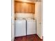 Efficient laundry room with washer, dryer, and overhead cabinet storage at 35 E Agate Ave # 208, Las Vegas, NV 89123