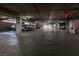 A long concrete parking garage featuring rows of parked cars, and overhead lighting at 35 E Agate Ave # 208, Las Vegas, NV 89123