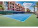Community tennis court with clear blue surface and green border surrounded by lush landscaping at 35 E Agate Ave # 208, Las Vegas, NV 89123