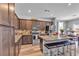 Open concept kitchen with island, granite countertops, stainless appliances and dark wood cabinets at 3964 E Marathon Dr, Pahrump, NV 89061