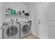 Modern laundry room with washer and dryer, shelving, storage, and tiled flooring at 3964 E Marathon Dr, Pahrump, NV 89061