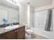 Well-lit bathroom with granite counters, stylish fixtures and shower and tub at 4563 Townwall St, Las Vegas, NV 89115