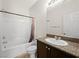 Cozy bathroom featuring a shower-tub combination, granite countertop vanity, and white tiles at 4563 Townwall St, Las Vegas, NV 89115