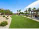 Beautiful community green space with picnic area, lush lawns, and mature palm trees at 4563 Townwall St, Las Vegas, NV 89115