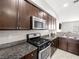 Well-equipped kitchen featuring stainless steel appliances, granite countertops and dark cabinetry at 4563 Townwall St, Las Vegas, NV 89115