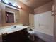 Full bathroom features a shower-tub combo, dark cabinets and a circular mirror at 4704 Wild Oak Way, North Las Vegas, NV 89031