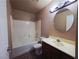 Full bathroom features a shower-tub combo, dark cabinets and a circular mirror at 4704 Wild Oak Way, North Las Vegas, NV 89031