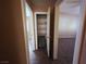 Hallway view featuring neutral walls, tile flooring, and open doorways that reveal spacious rooms at 4704 Wild Oak Way, North Las Vegas, NV 89031