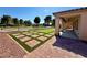 Backyard patio with outdoor kitchen, pavers, and artificial grass at 5235 E La Campana Dr, Pahrump, NV 89061