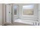 Relaxing bathroom featuring a soaking tub, a glass-enclosed shower, and a frosted window at 5235 E La Campana Dr, Pahrump, NV 89061