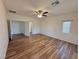 A simple bedroom with wood-look floors, ceiling fan, and a window at 5235 E La Campana Dr, Pahrump, NV 89061
