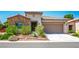 Single-story home featuring stone accents, desert landscaping, and a two-car garage at 5235 E La Campana Dr, Pahrump, NV 89061