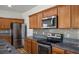 Modern kitchen featuring stainless steel appliances, granite countertops, and wood cabinetry at 5235 E La Campana Dr, Pahrump, NV 89061