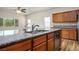 A kitchen island with a stainless steel sink and faucet, granite countertops and wood cabinets at 5235 E La Campana Dr, Pahrump, NV 89061