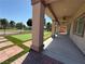 A covered patio with a view of the manicured backyard, featuring pavers and artificial grass at 5235 E La Campana Dr, Pahrump, NV 89061
