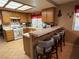 Bright kitchen with oak cabinets, tiled countertops, breakfast bar, and a full range of appliances at 5517 Rock Creek Ln, Las Vegas, NV 89130