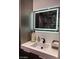 Modern bathroom featuring a sleek vanity with a built-in sink and an illuminated mirror at 5568 Yellow Ash St, Las Vegas, NV 89118