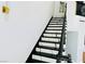 A contemporary staircase featuring black and white steps complemented by a sleek black banister at 5568 Yellow Ash St, Las Vegas, NV 89118