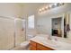 Bright bathroom featuring a single sink vanity, toilet, and shower with glass doors at 5730 Coleman St, North Las Vegas, NV 89031