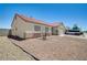 View of the neutral colored single-story home showing the rock yard and long driveway at 5730 Coleman St, North Las Vegas, NV 89031