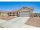 A neutral colored single-story home with two car garage and low maintenance landscaping at 5730 Coleman St, North Las Vegas, NV 89031