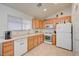 Cozy kitchen featuring wood cabinets and white appliances, bathed in natural light at 5730 Coleman St, North Las Vegas, NV 89031