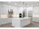 Bright kitchen featuring white cabinets, marble countertops, stainless appliances, and pendant lights over island at 605 Canyon Greens Drive Dr, Las Vegas, NV 89144