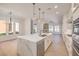 Bright kitchen boasts an island with quartz countertop, stainless steel appliances, and pendant lighting at 605 Canyon Greens Drive Dr, Las Vegas, NV 89144